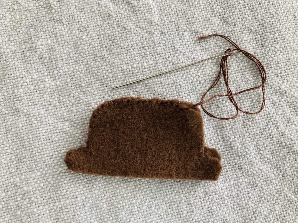 Two felt hat pieces being sewn together