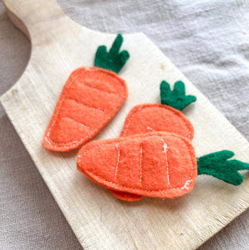 Felt Carrots on a wooden cutting board